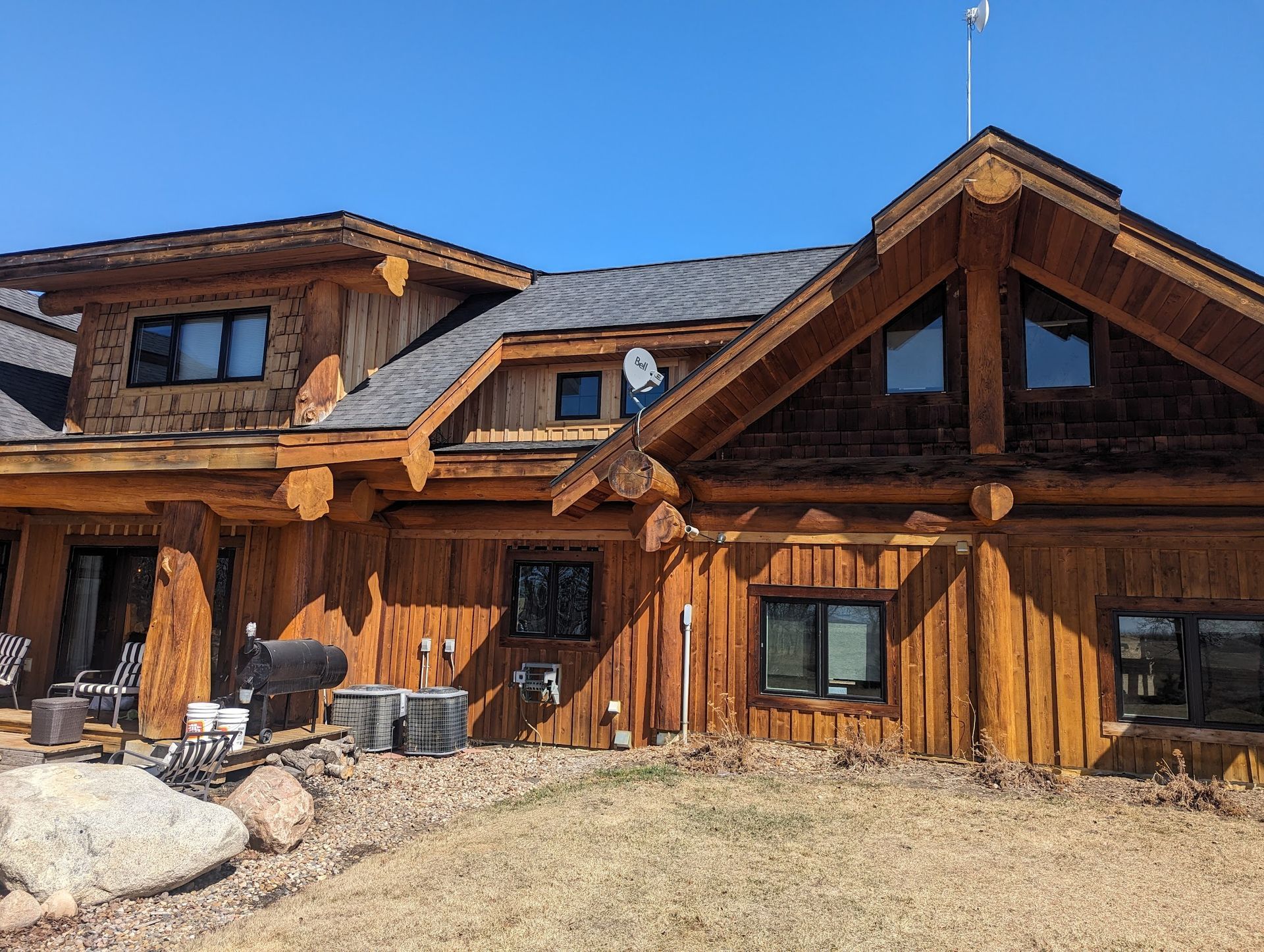 A large log cabin with a satellite dish on the roof