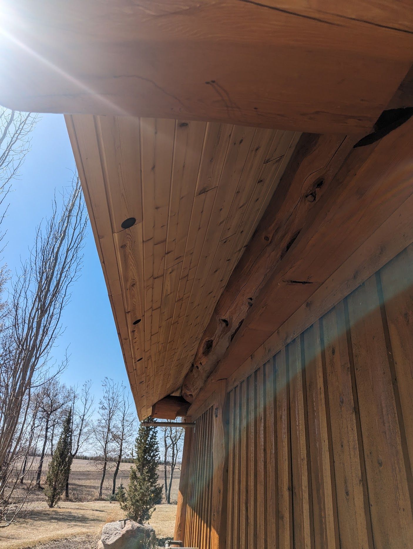A wooden building with a roof that is covered in wood.