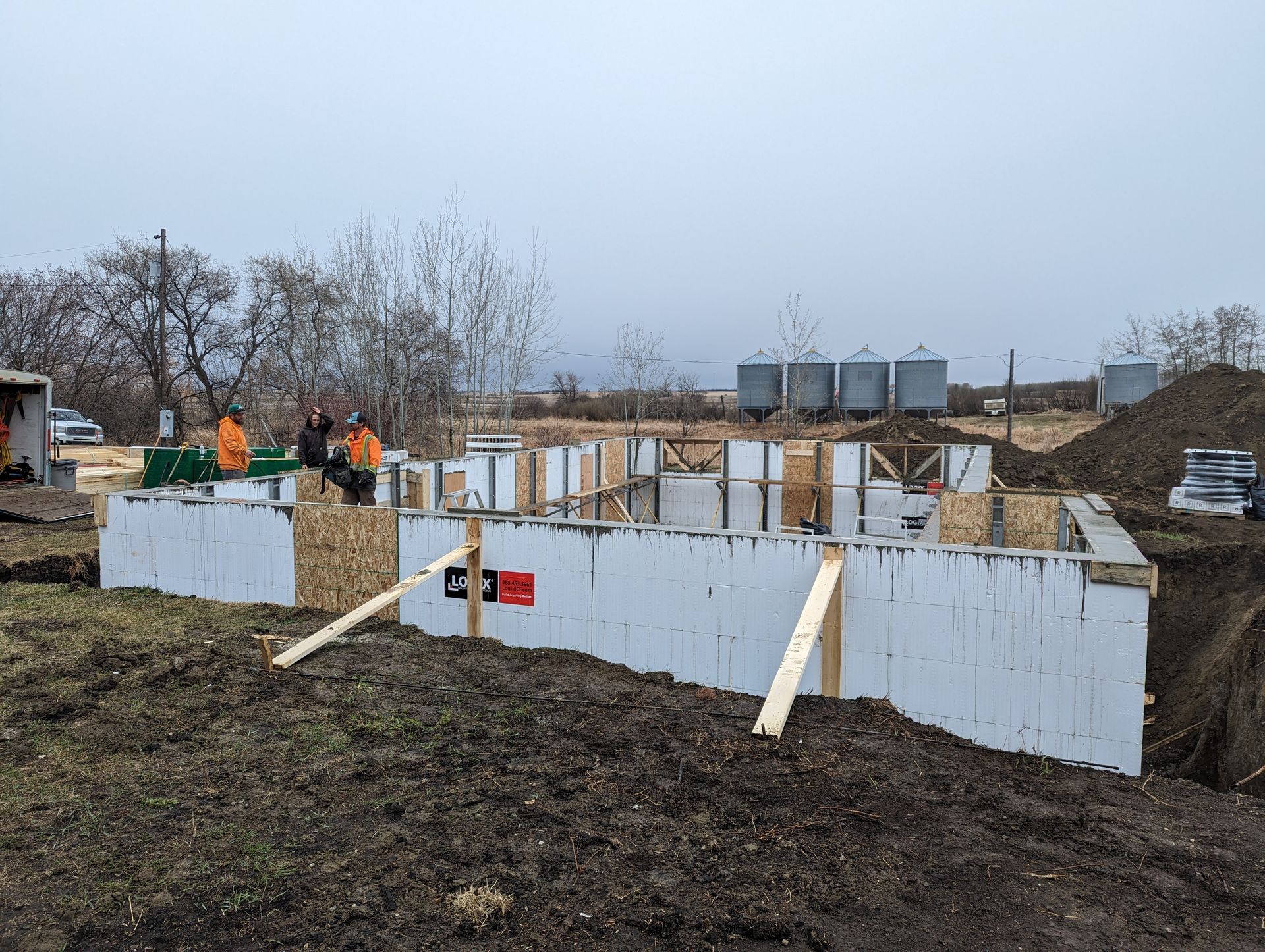 A group of construction workers are working on a house foundation.