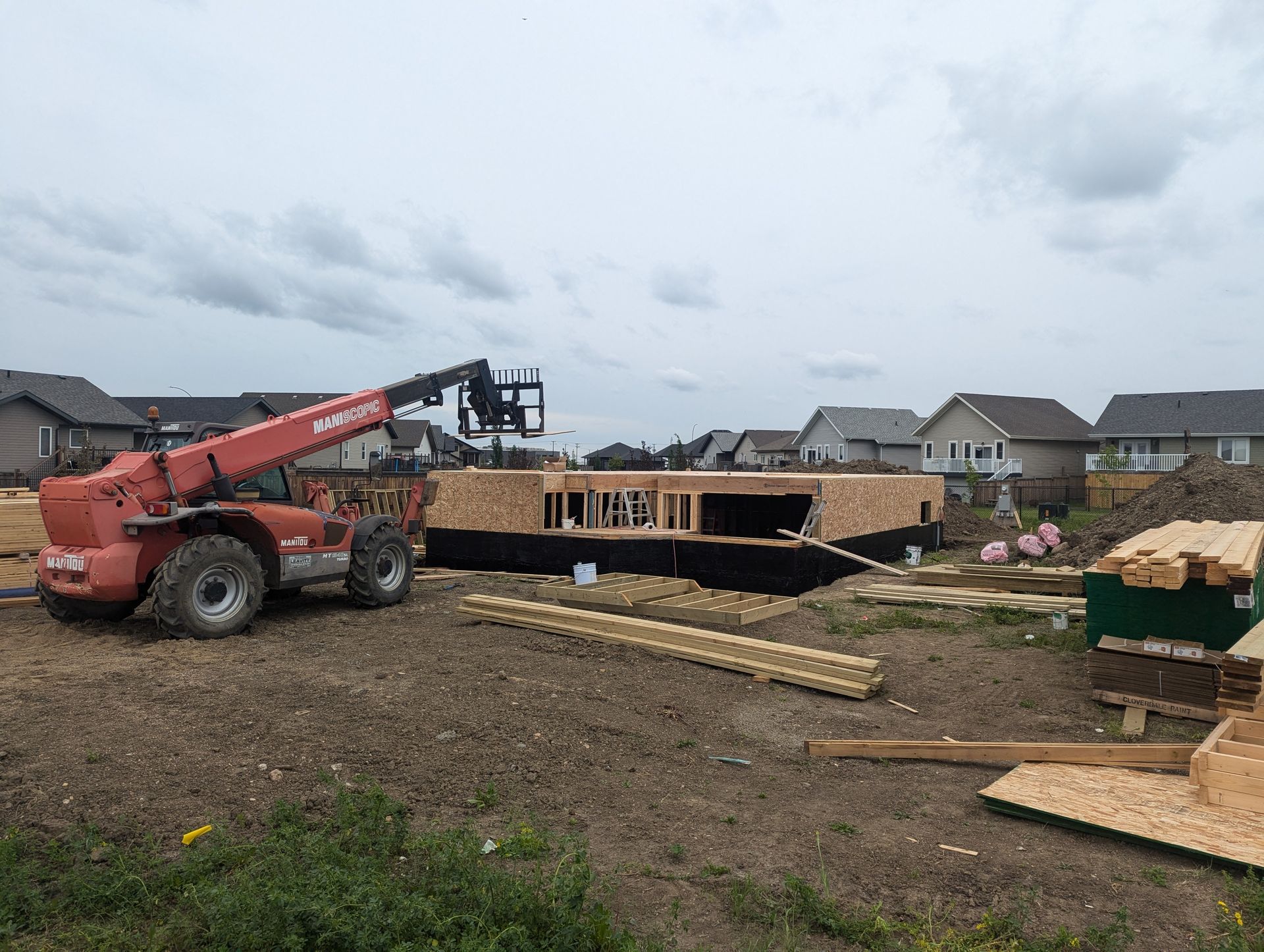 A construction site with a tractor and a forklift.