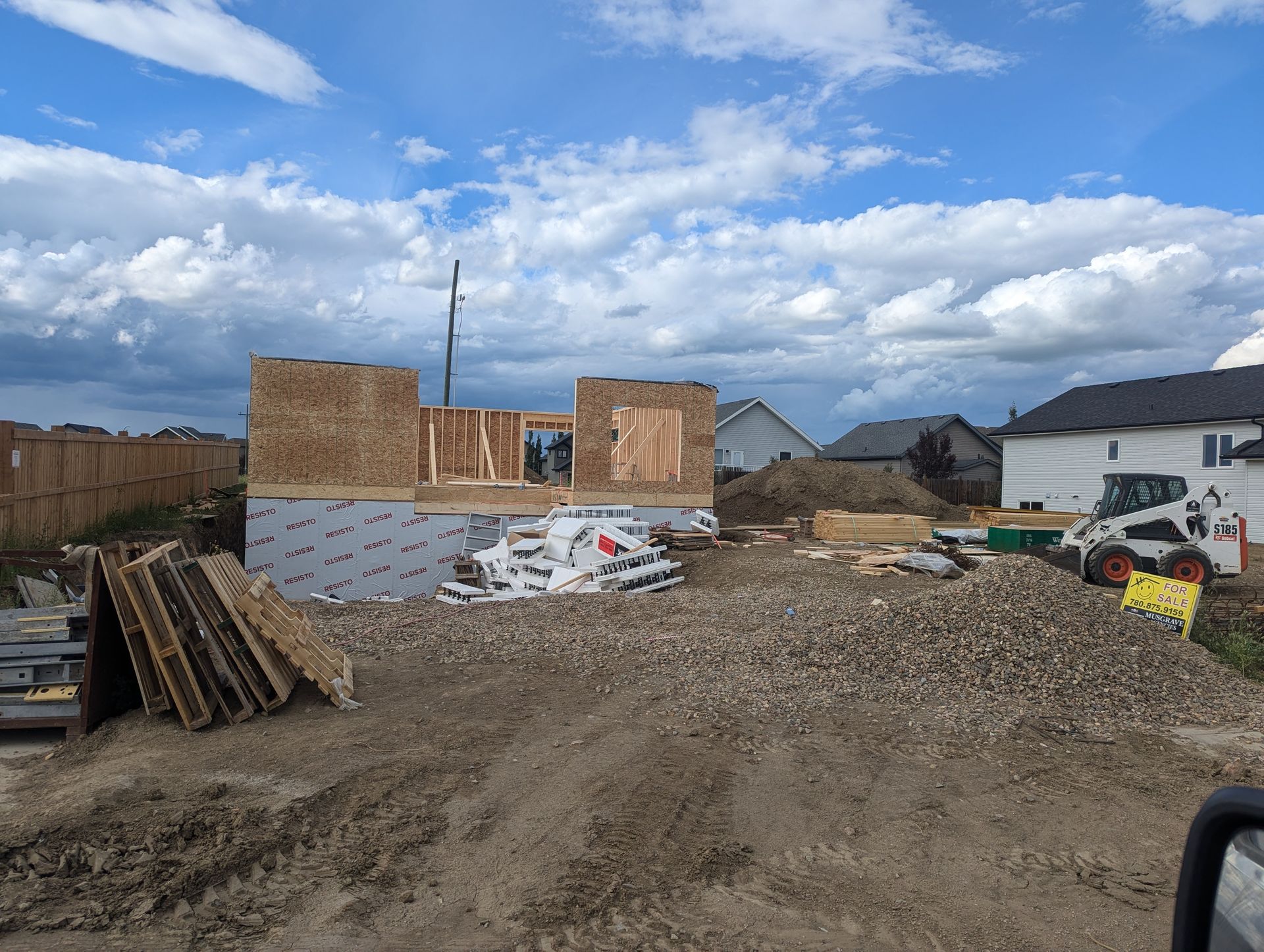 A house is being built in the middle of a dirt field.