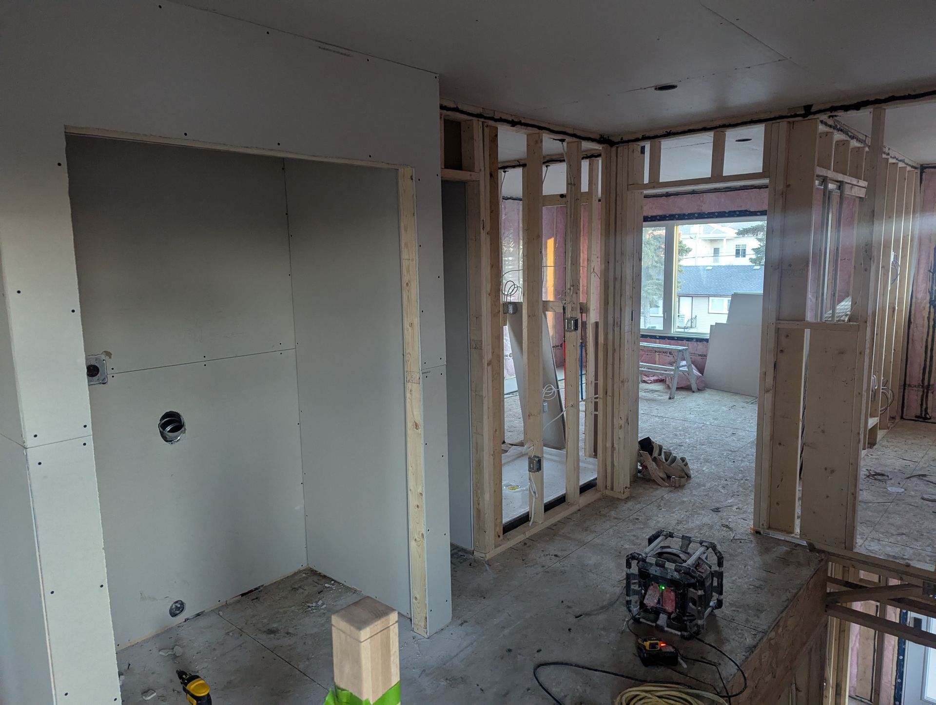 Interior view of a building under construction, showing drywall and wooden framing.