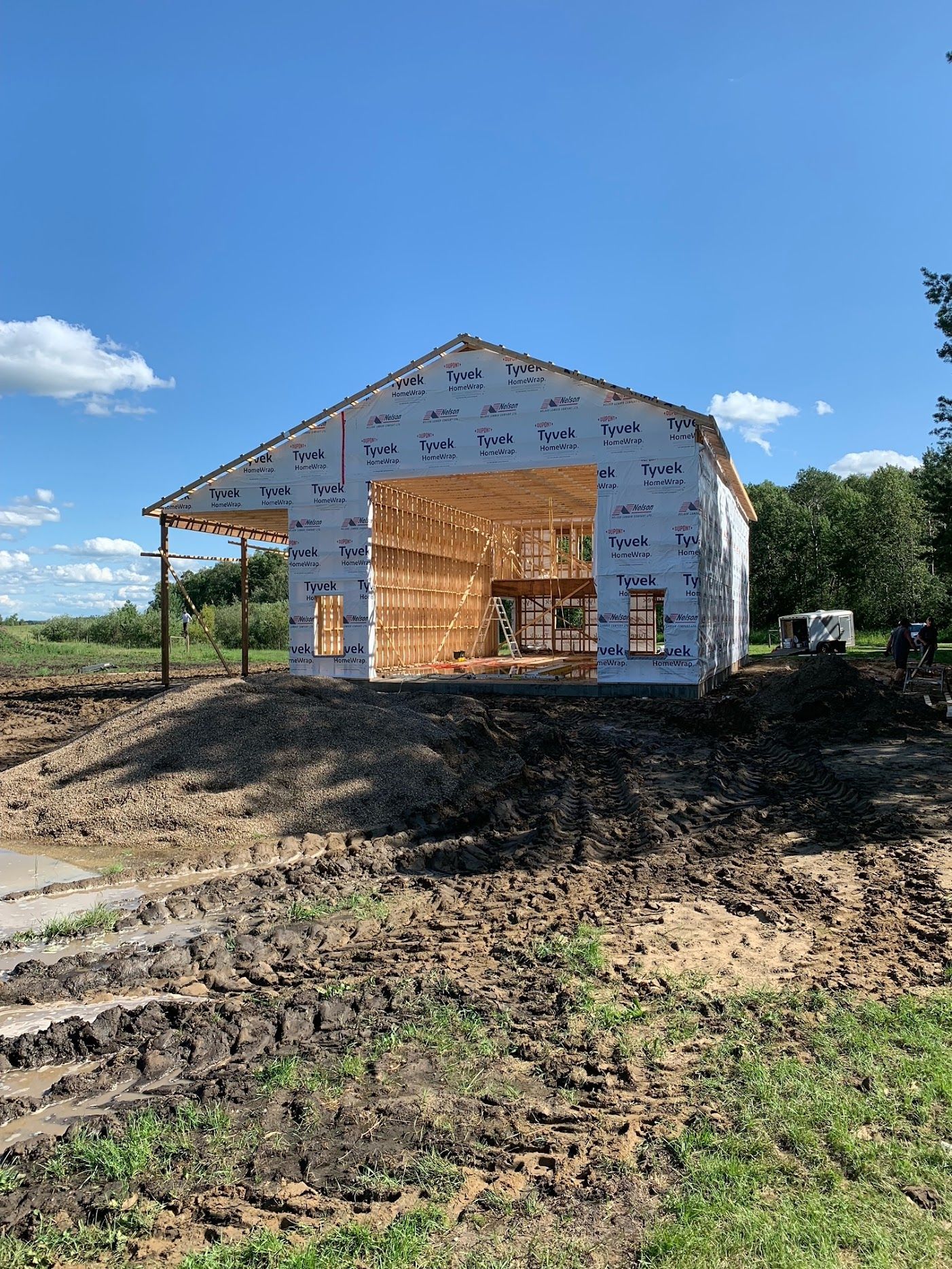 A large building is being built in the middle of a dirt field.