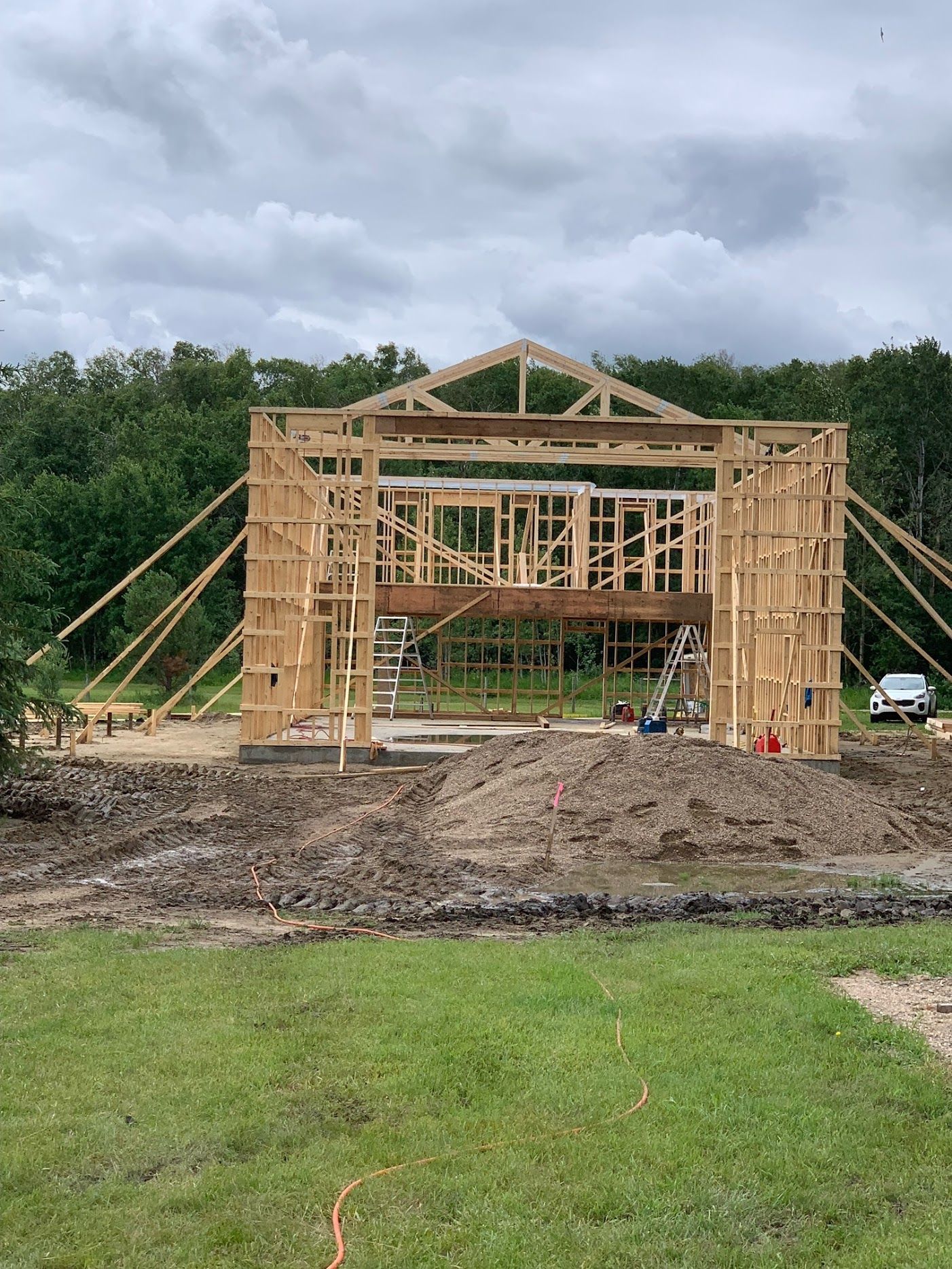 A large wooden structure is being built in a field.