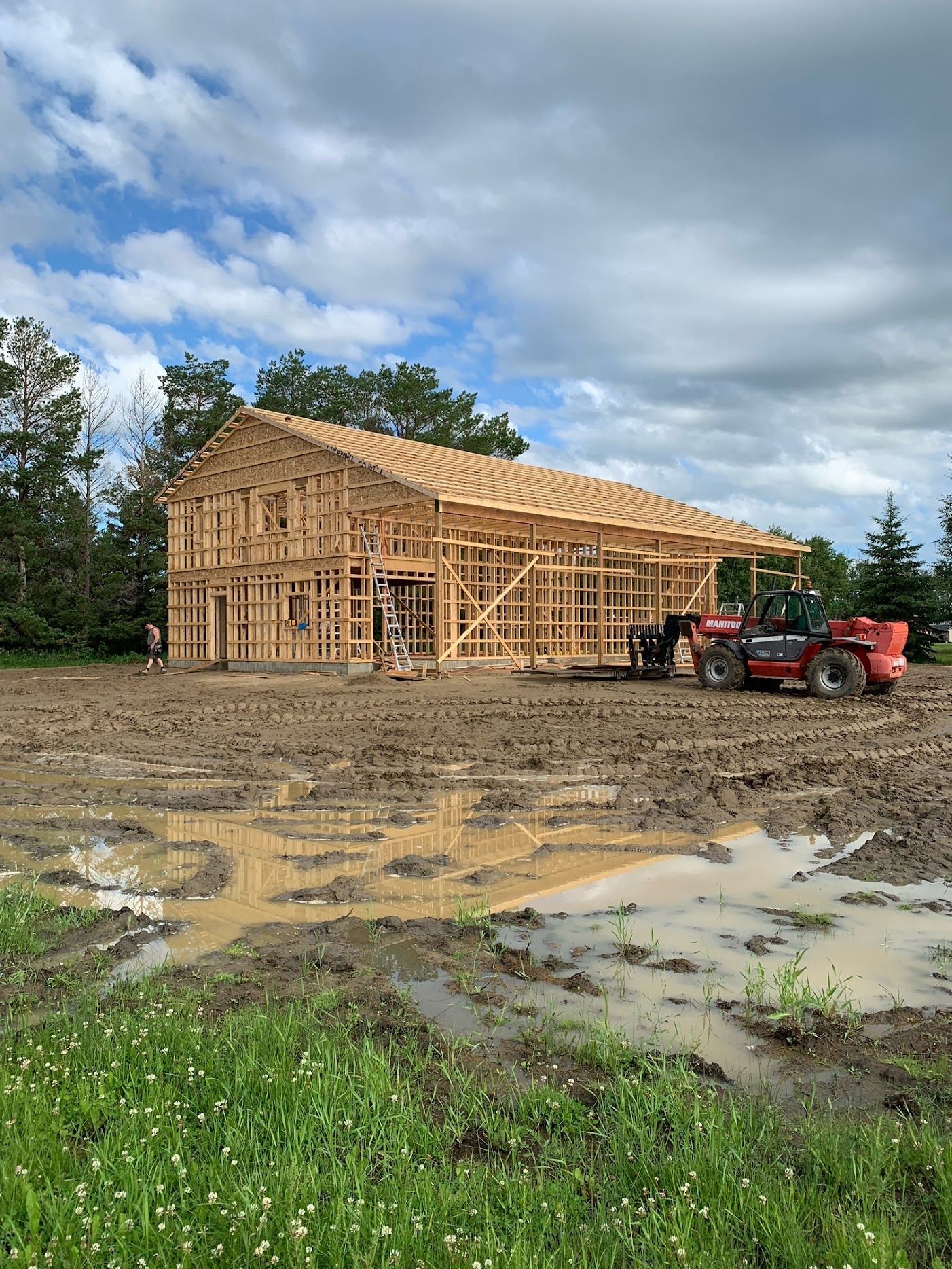 A house is being built in a muddy field.