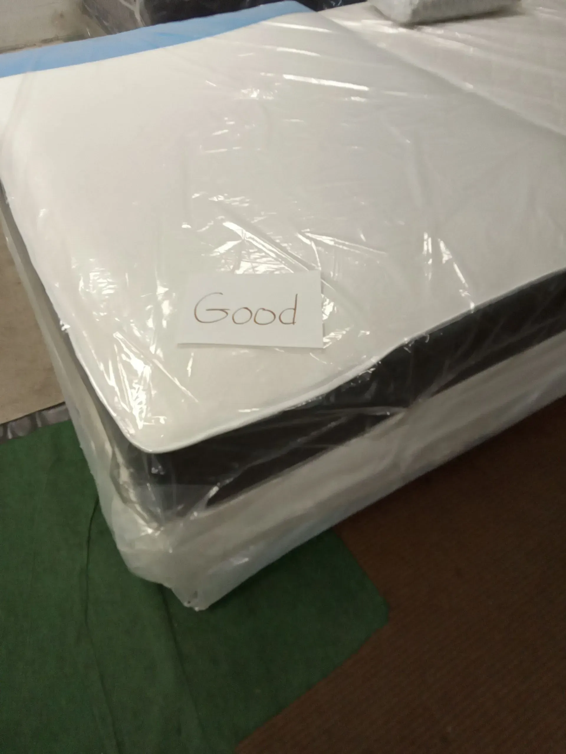 Stacked white-wrapped packages labeled “Good” on a green floor