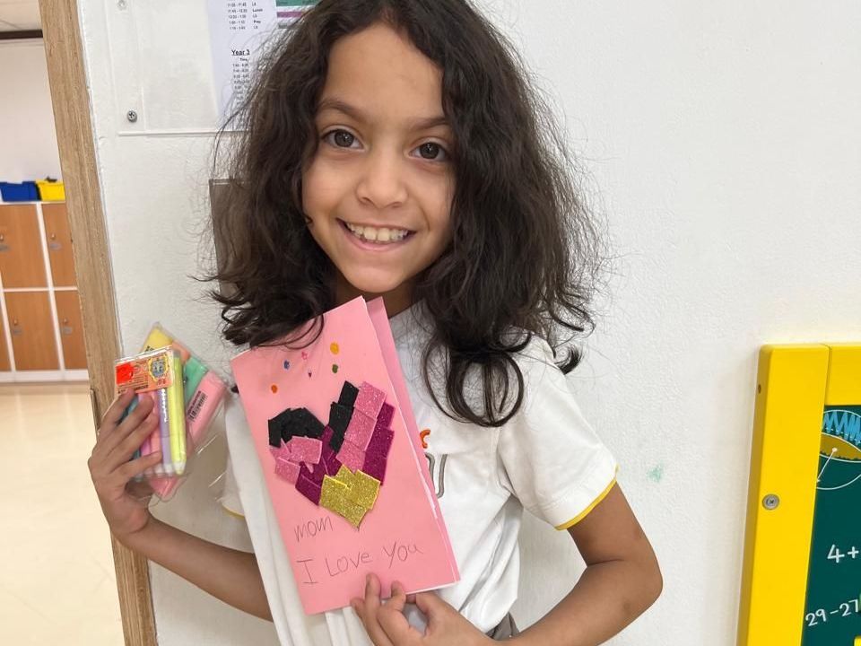 A young girl is holding a card that says `` i love you ''.