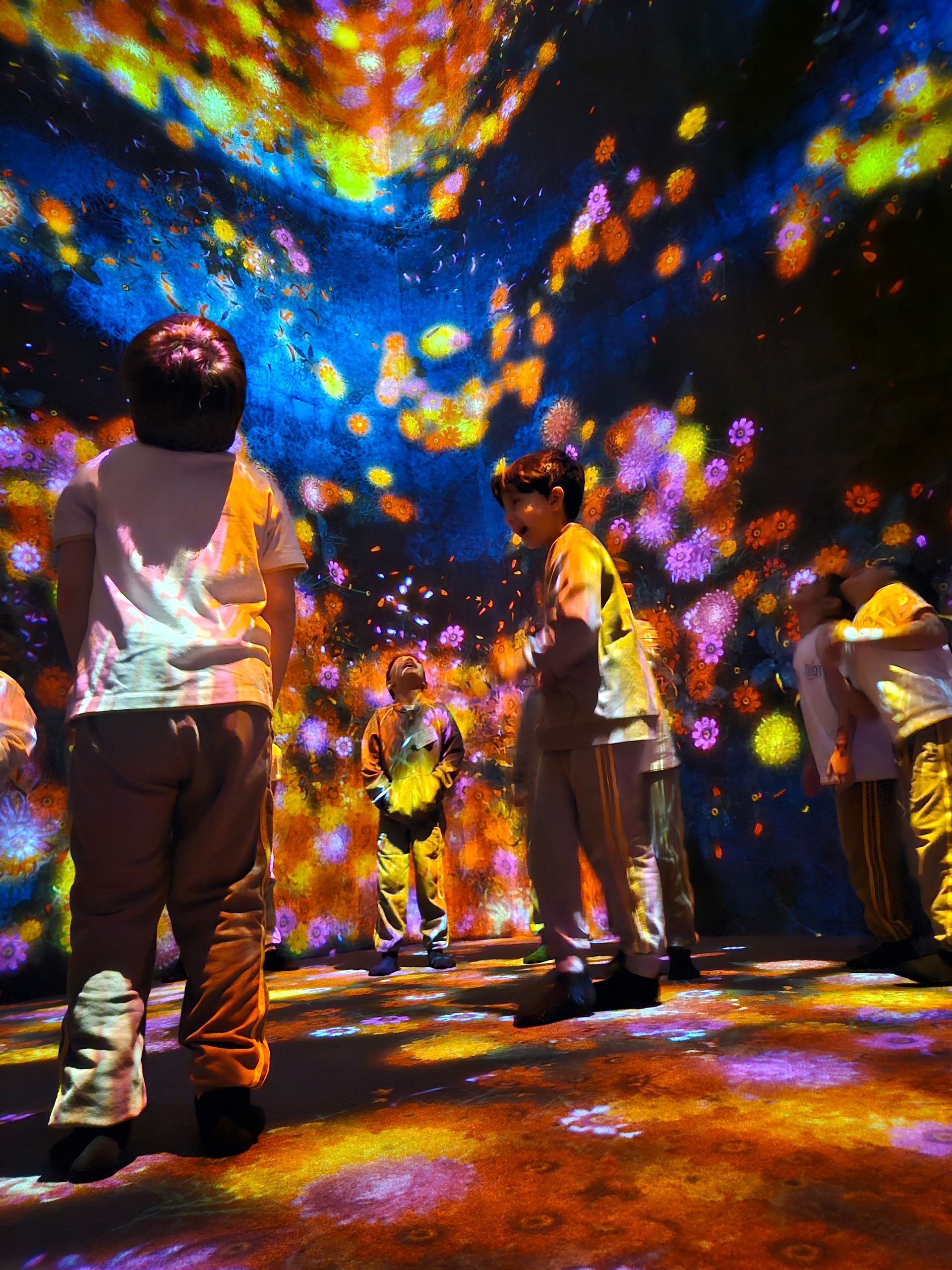 A group of people are standing in front of a colorful display