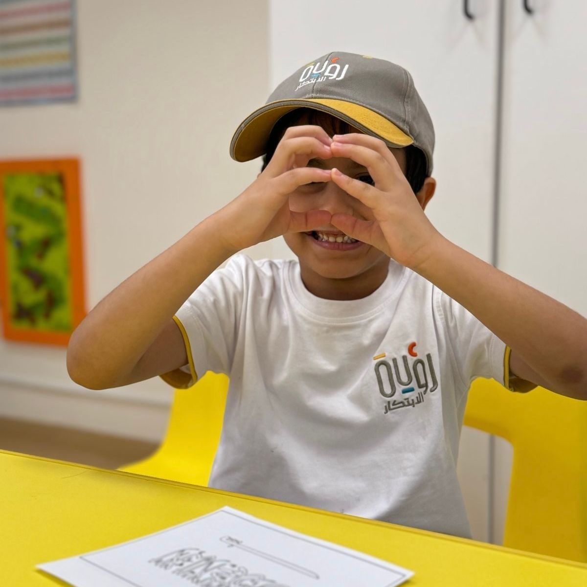 A young boy wearing a gray hat and a white shirt with the word oui on it