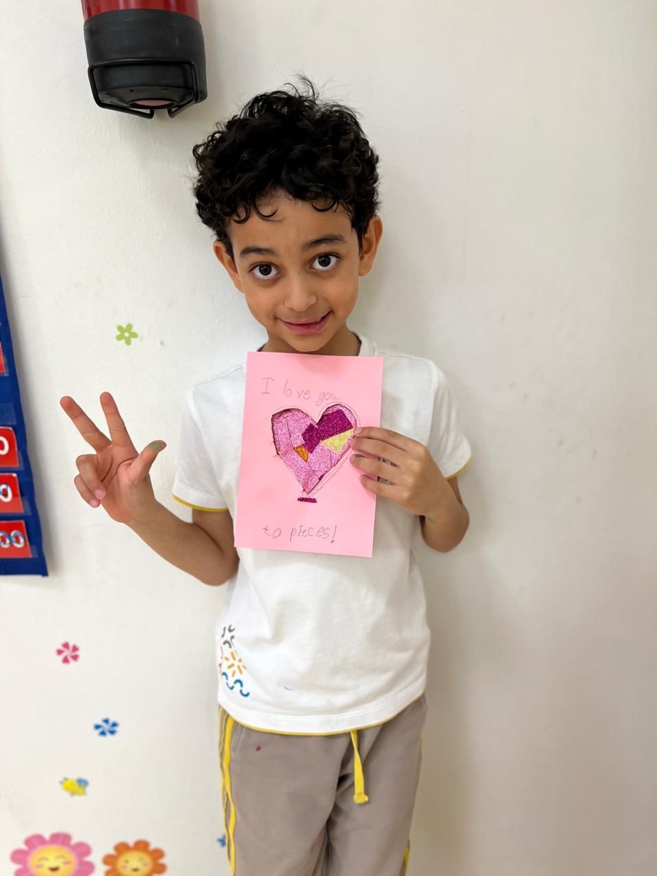 A young boy is holding a card with a heart on it