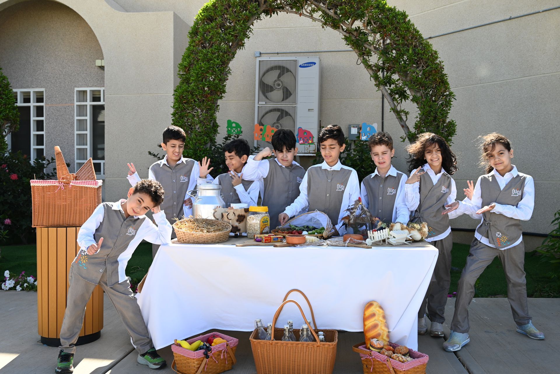 Primary school students around a table of fresh foods, smiling and exploring healthy eating.