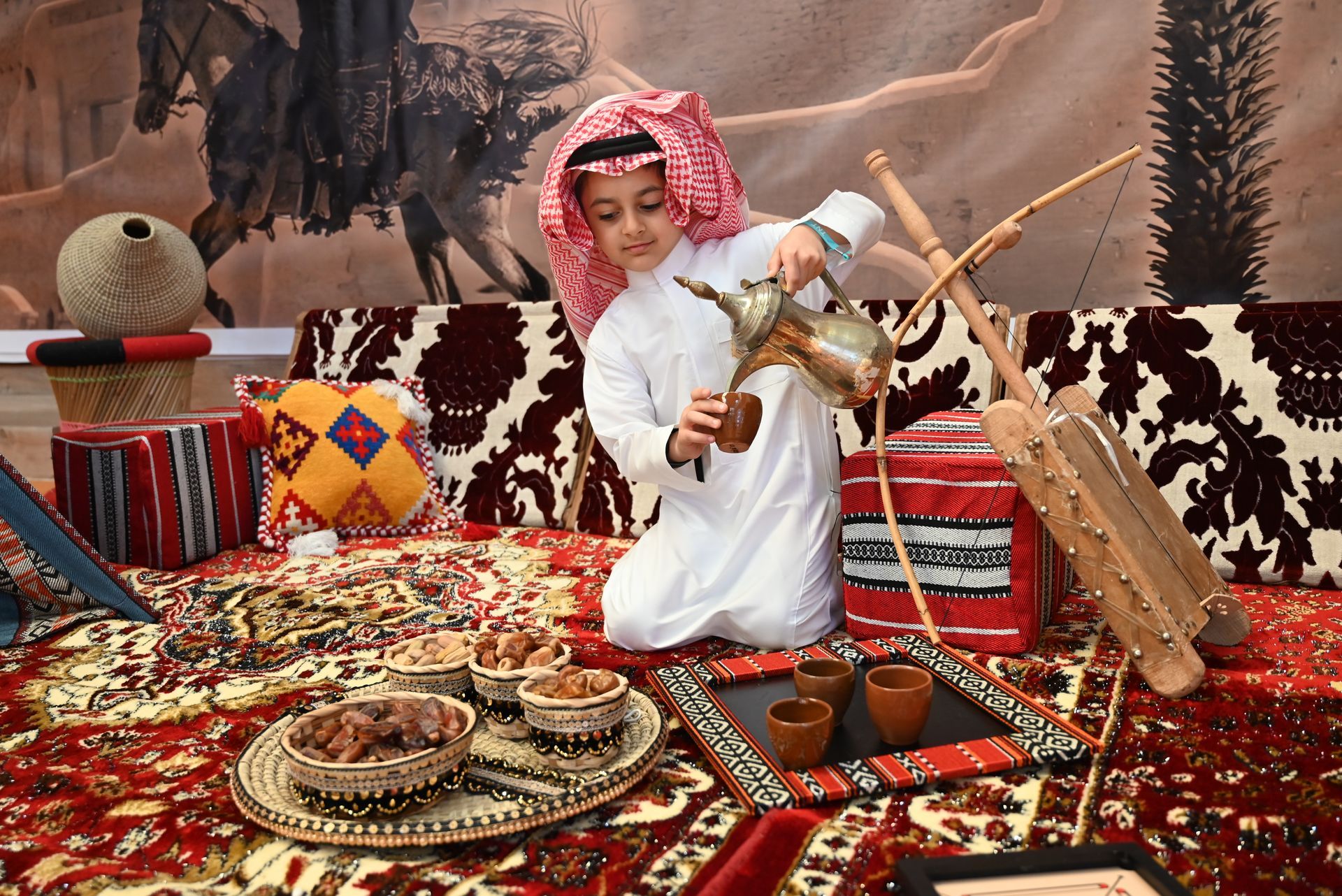 A young boy is kneeling on the floor playing a musical instrument.