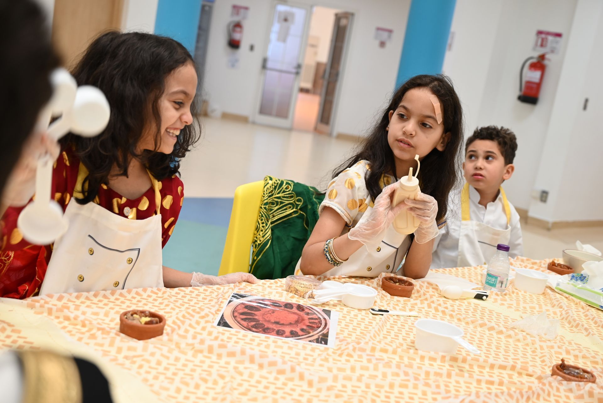 A group of children are sitting at a table making crafts.