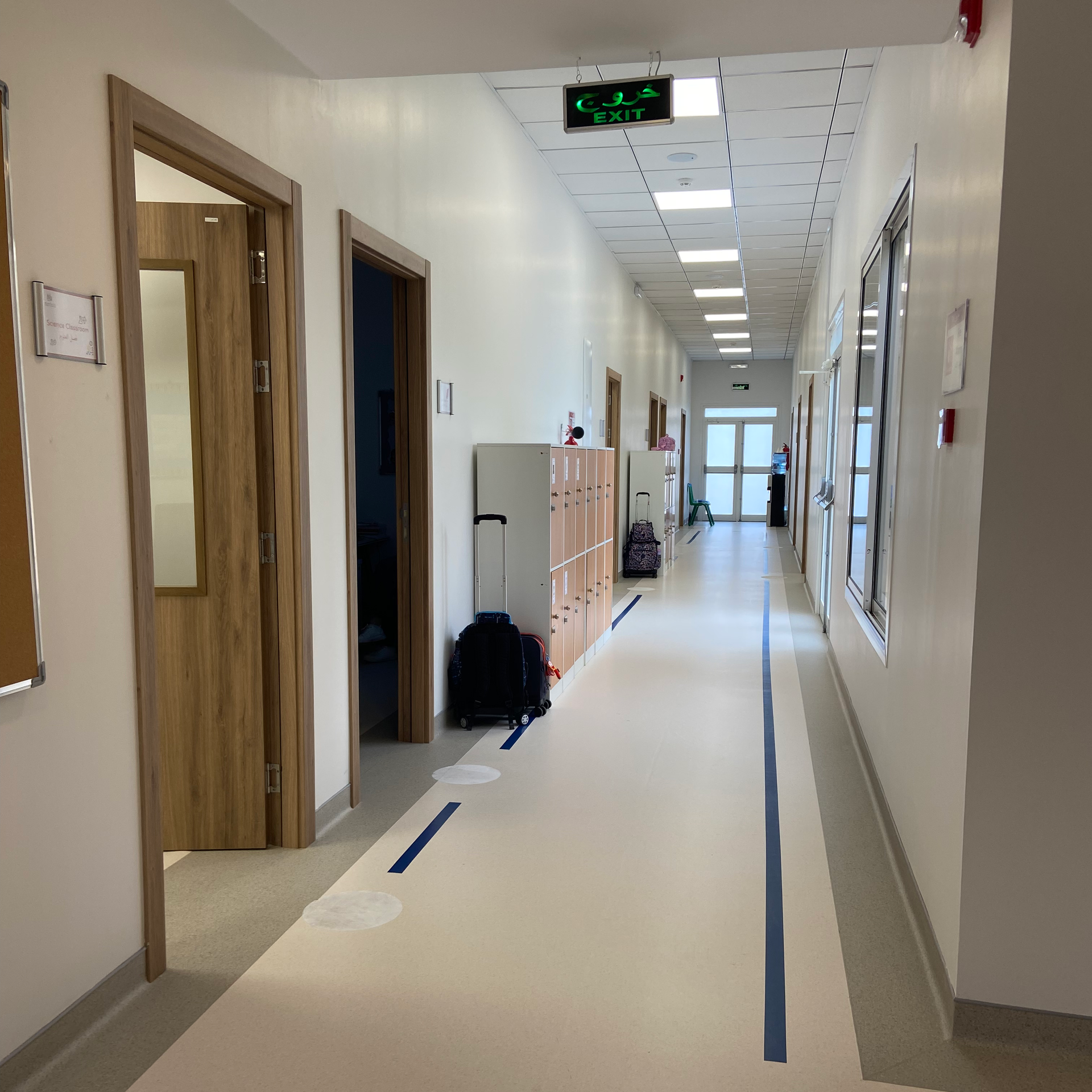 A group of young boys are sitting at a table drawing on papers