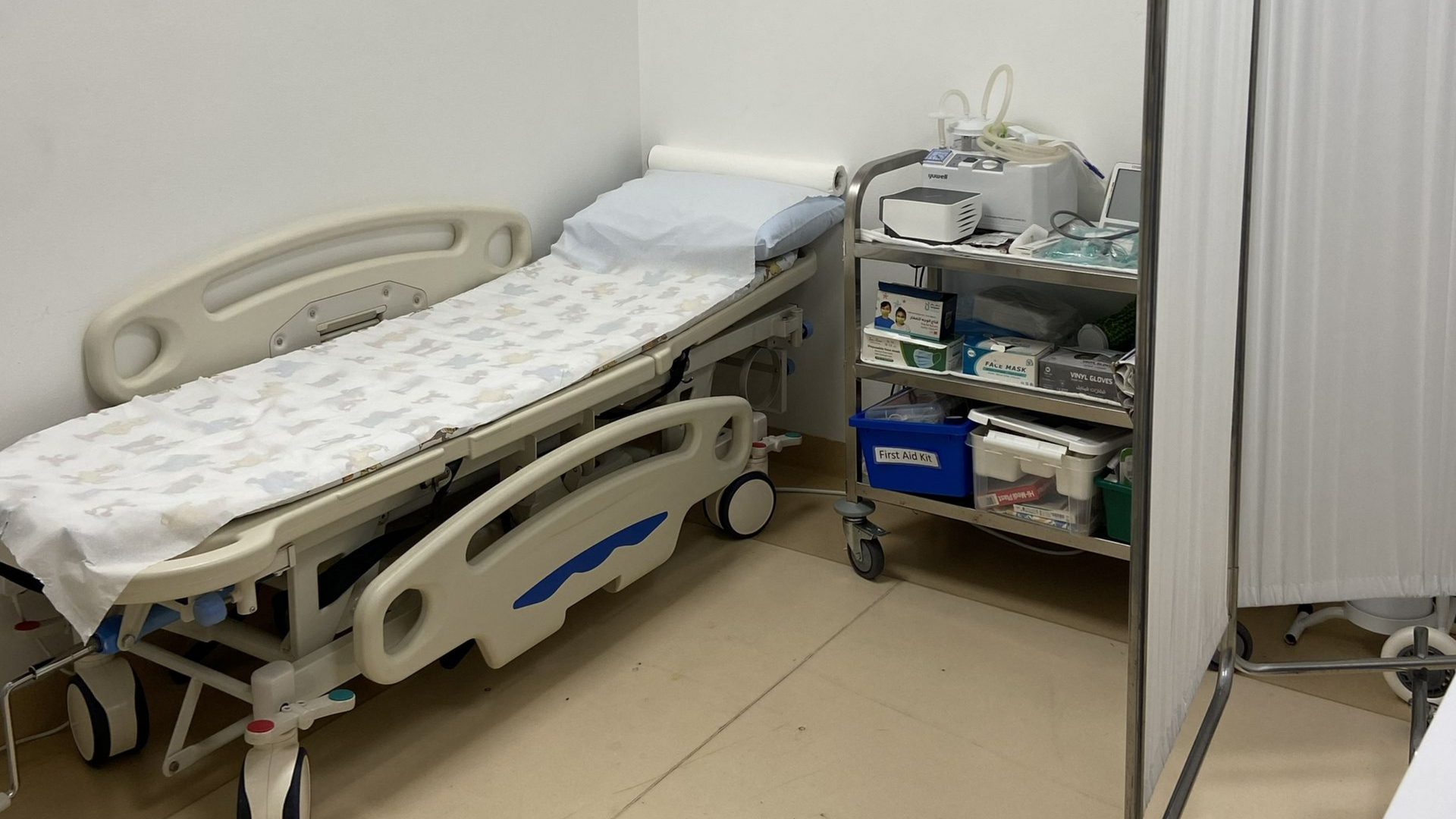 CPR and AED training setup in school medical room with hospital bed and emergency equipment