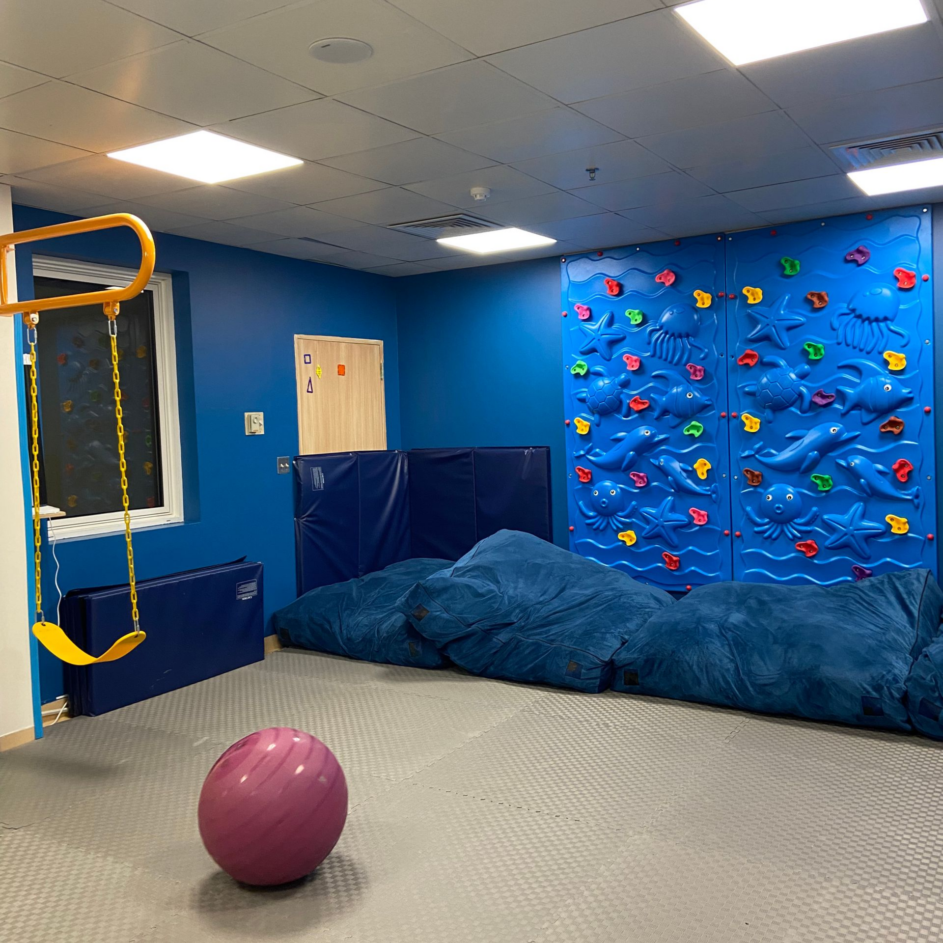 A boy and a girl are playing with a rabbit in a cage.