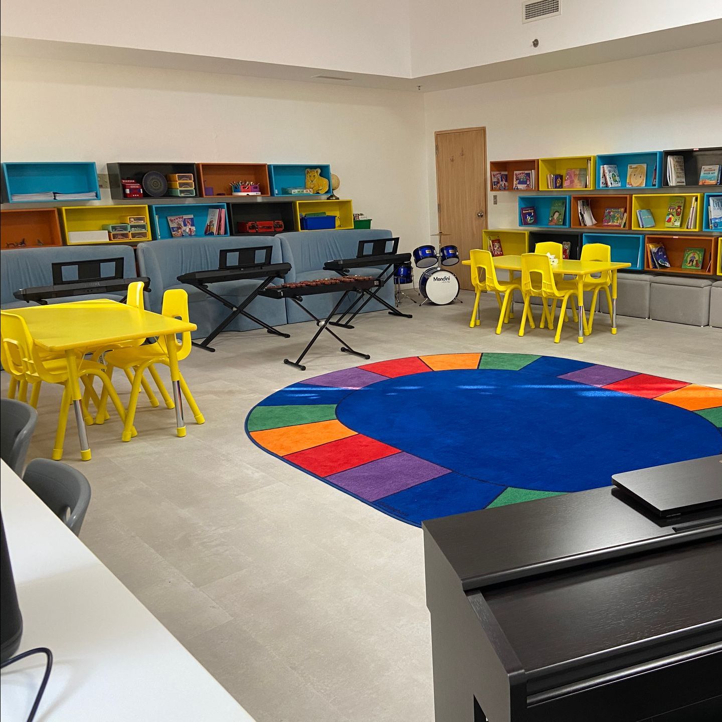 A room with tables and chairs and a blue rug