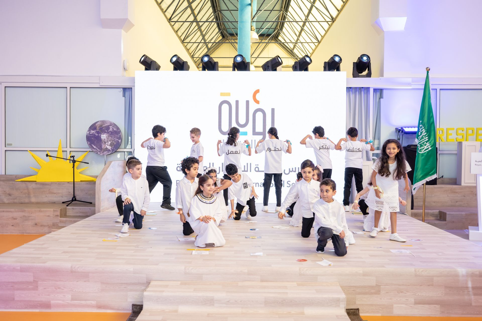 A group of children are dancing on a stage.