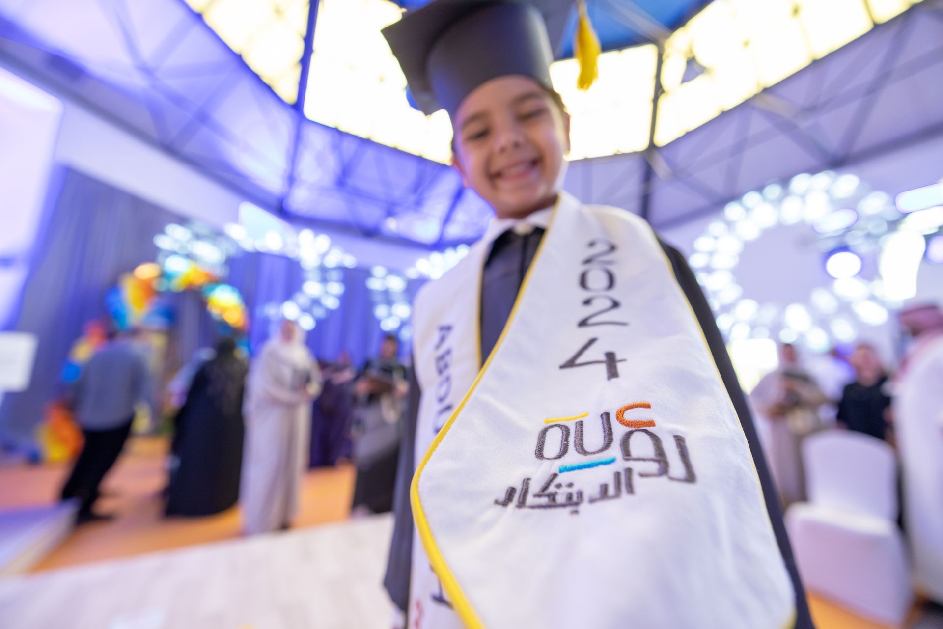 A young boy wearing a graduation cap and gown with the year 2014 on it