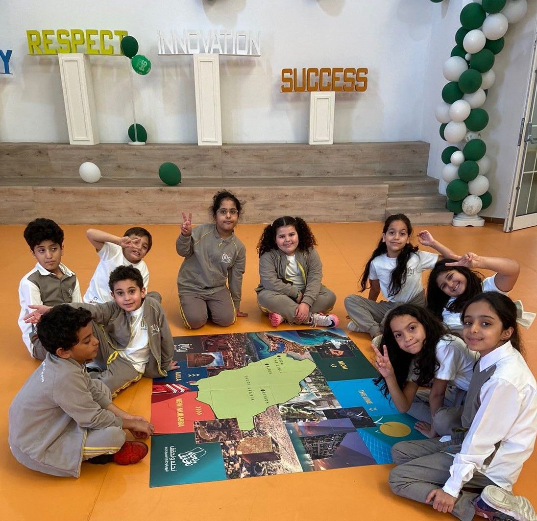 A group of children are sitting around a map that says respect innovation success