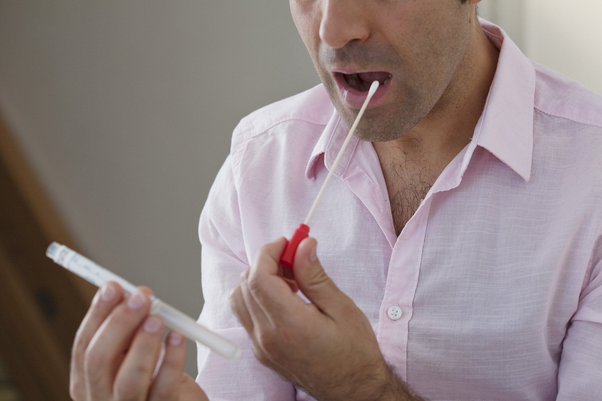 Man using a swab to send off for genetic testing