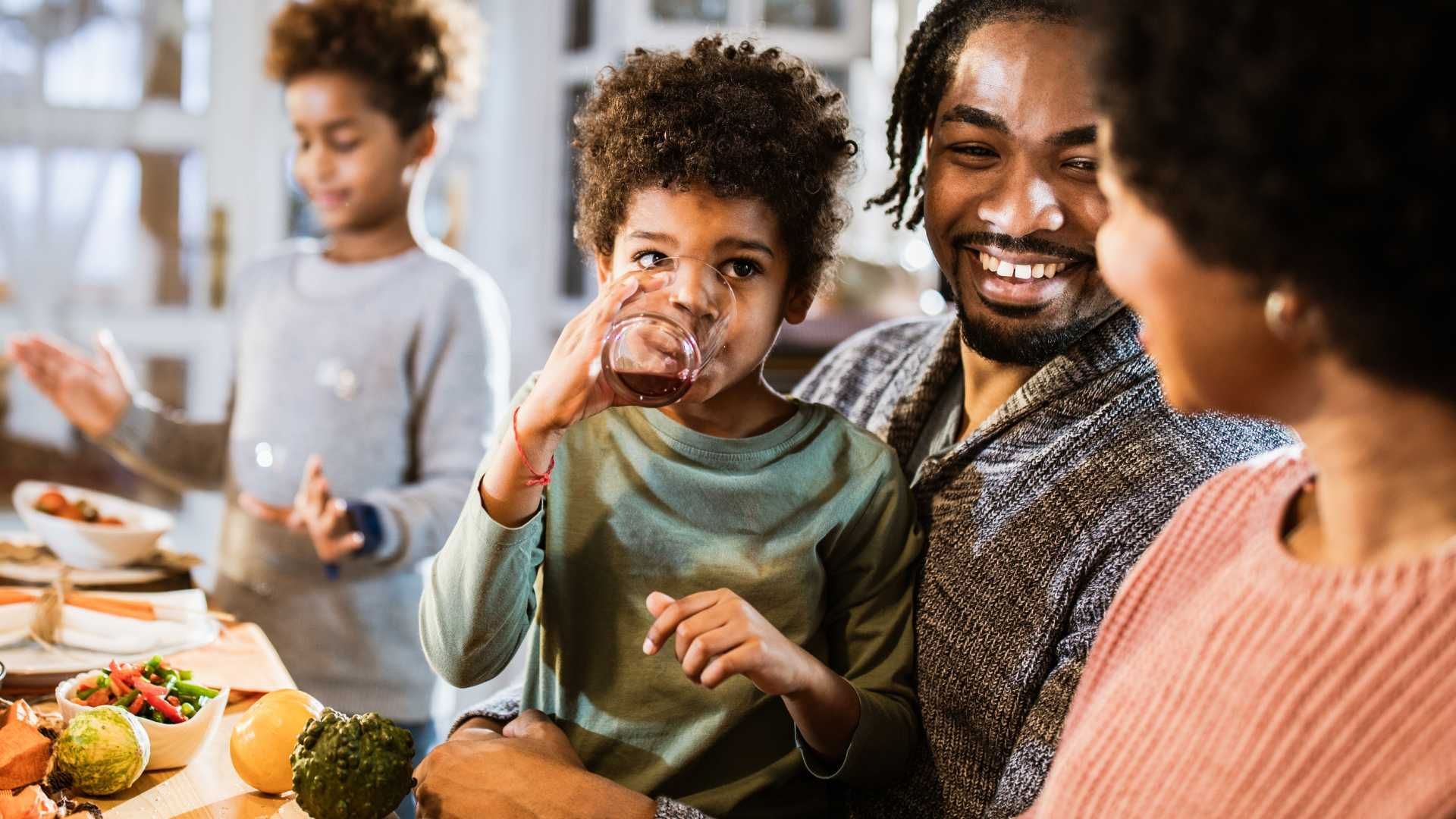black couple talking with their children eating and drinking