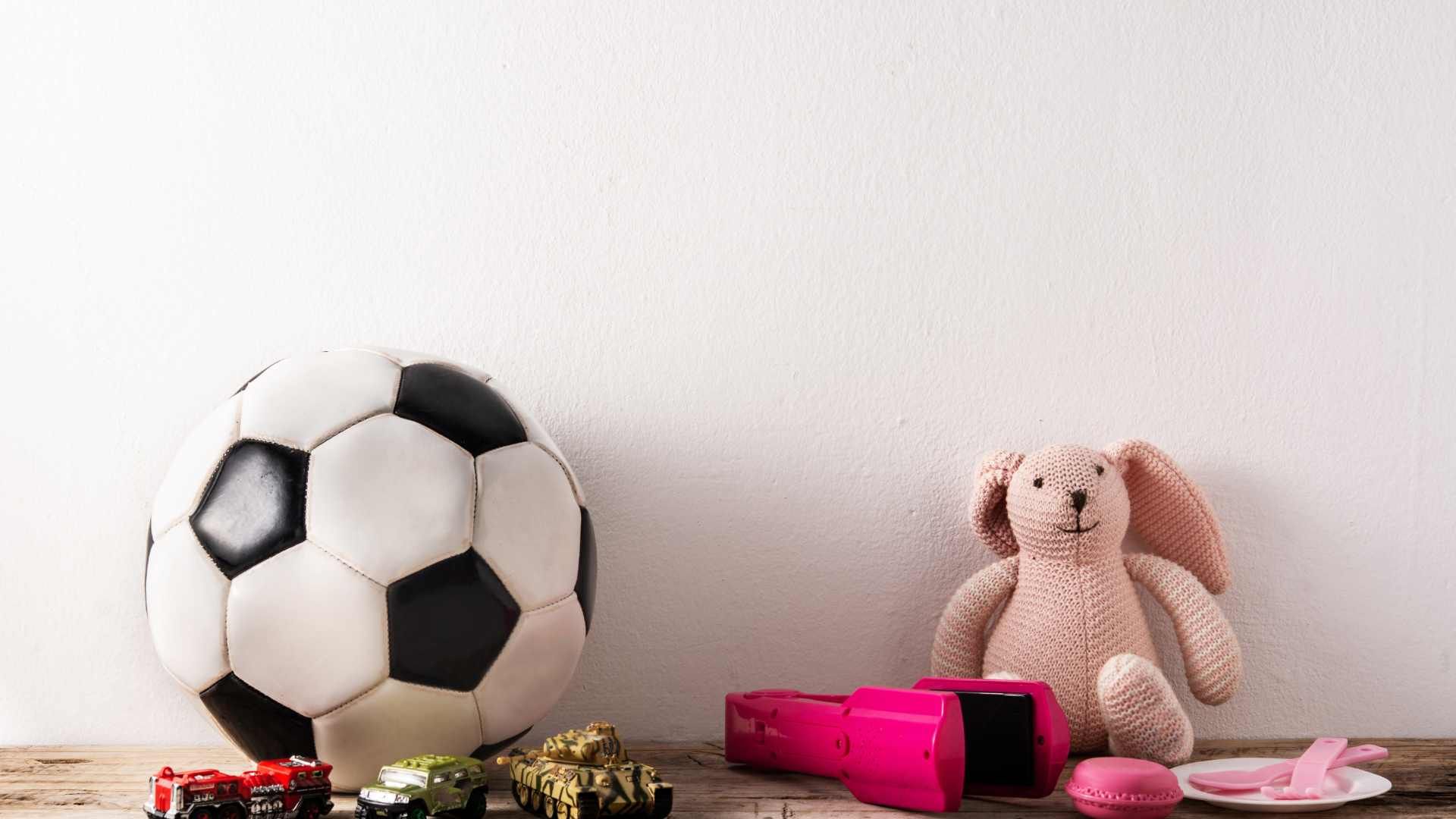 soccer ball hair iron and stuffed toy rabbit on top of a messy table