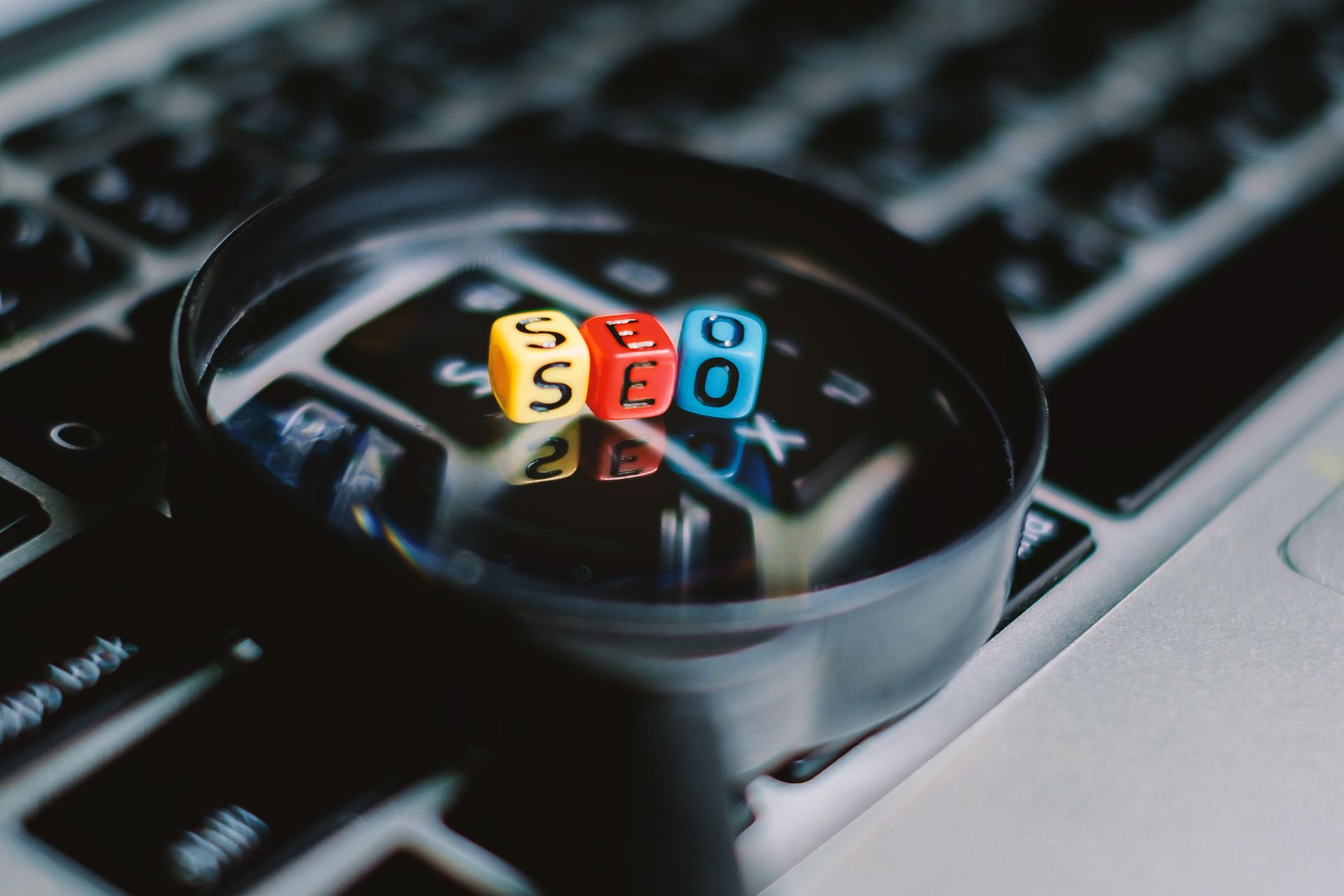 Magnifying glass on a laptop keyboard with colorful 