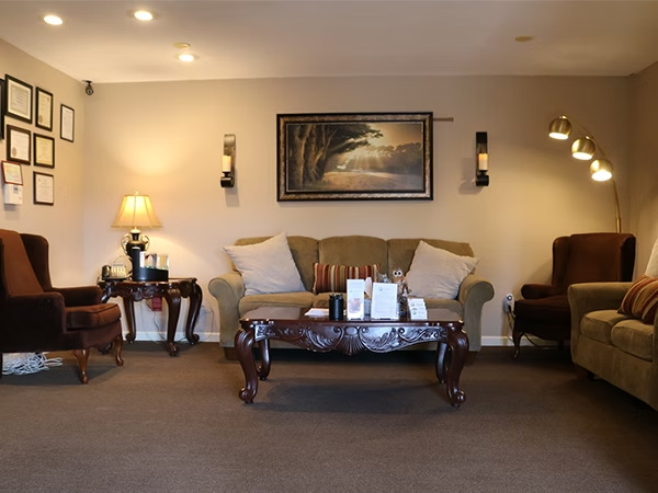 Dried floral arrangement against a dark background; olive green eucalyptus and golden brown ferns.