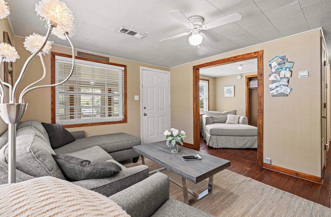Cozy living room with gray sectional sofa, wooden coffee table, and entry to another room.