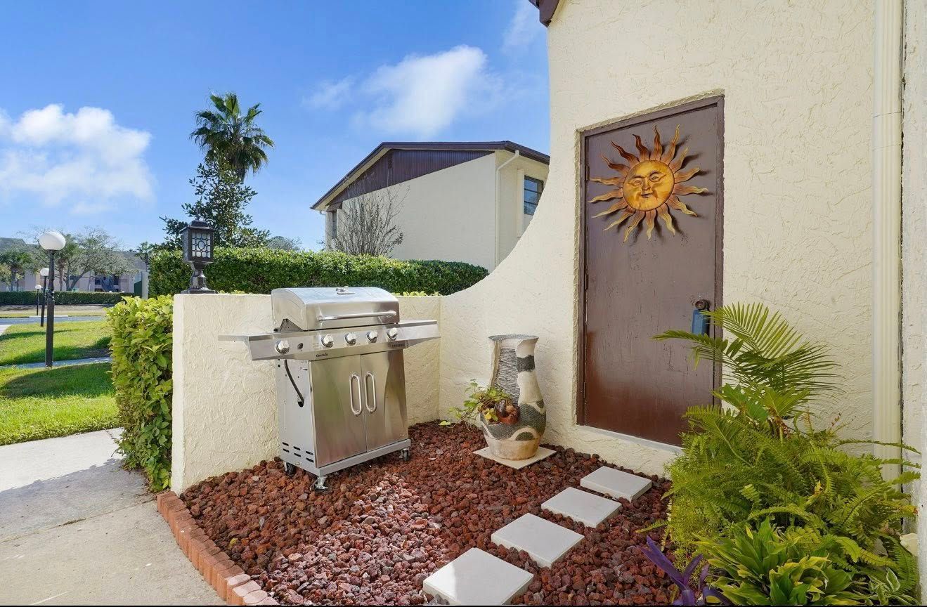 Outdoor patio with a grill, decorative sun door, and stepping stones.