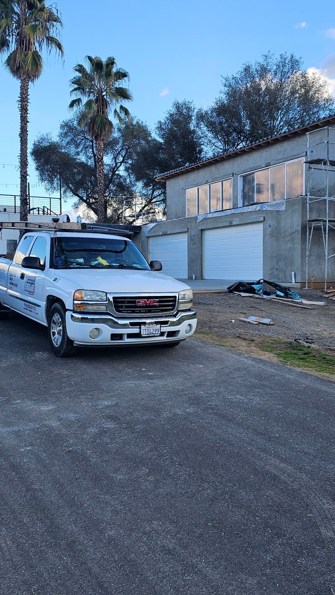 A white truck is parked on the side of the road in front of a building.