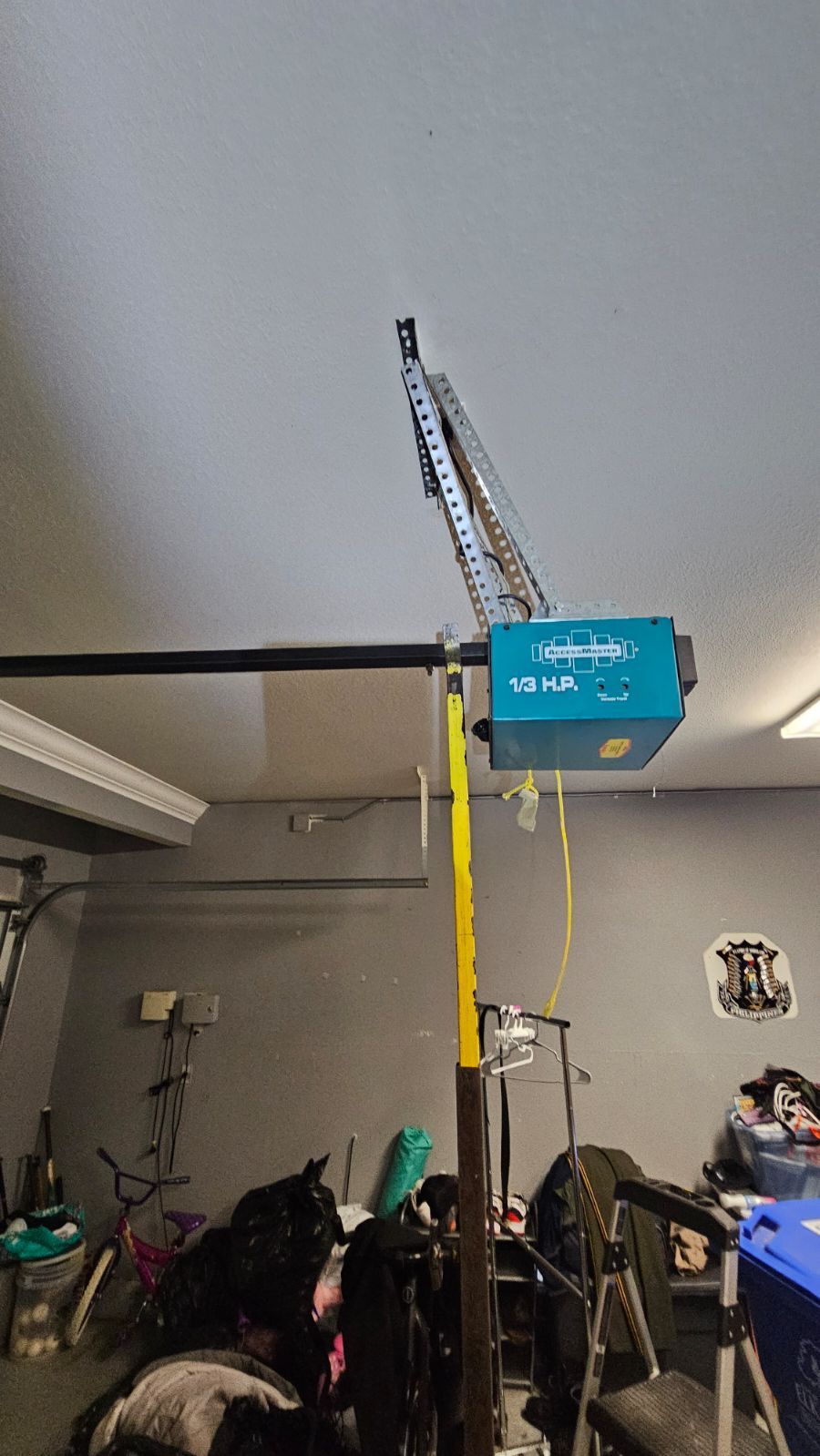 A blue box is hanging from the ceiling of a garage.