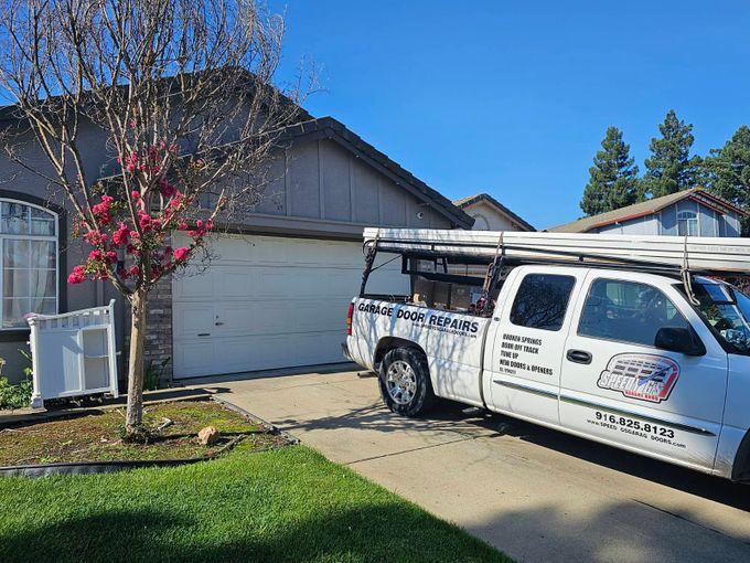 a garage door repair truck is parked in front of a house