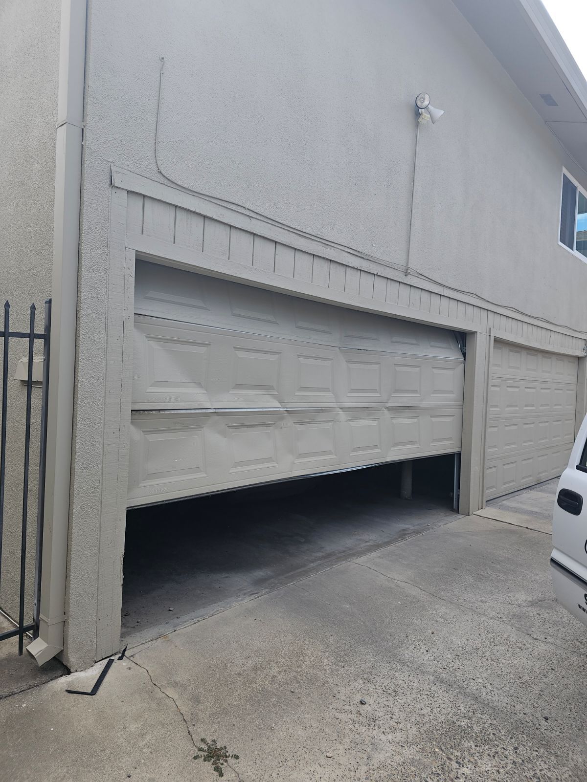 A car is parked in front of a garage door that is open.