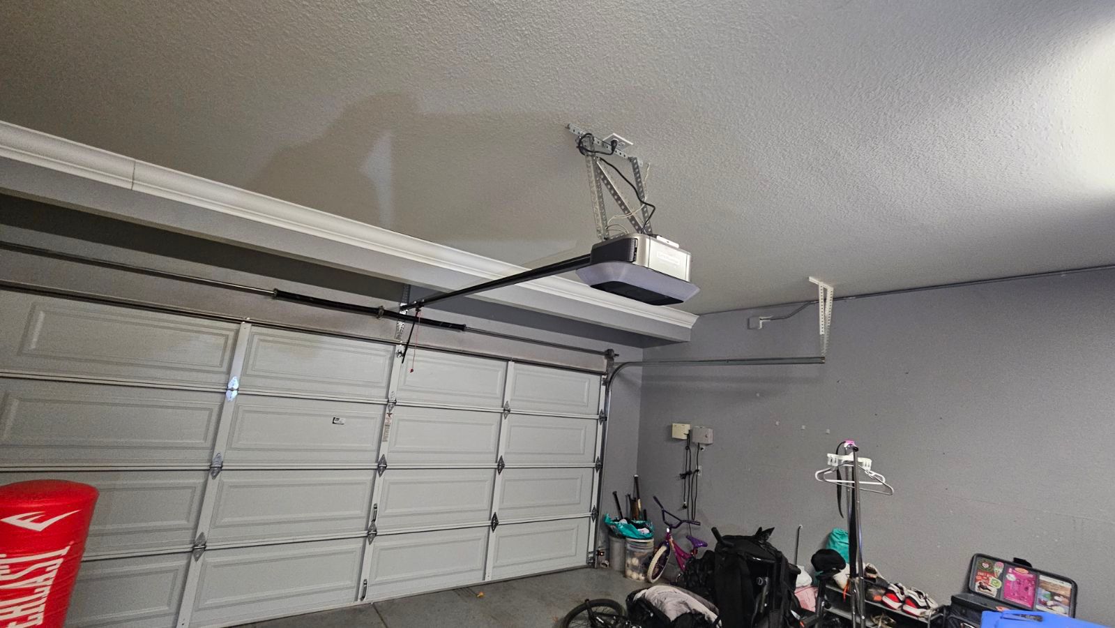 A garage with a garage door opener hanging from the ceiling.