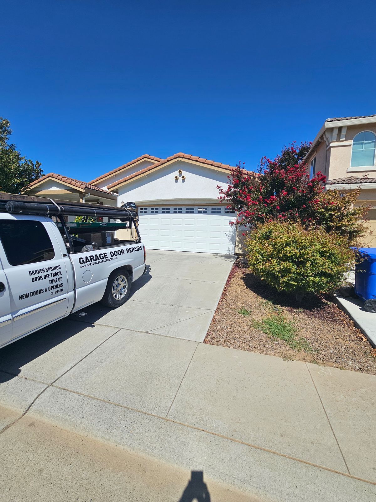 A white truck is parked in front of a house.