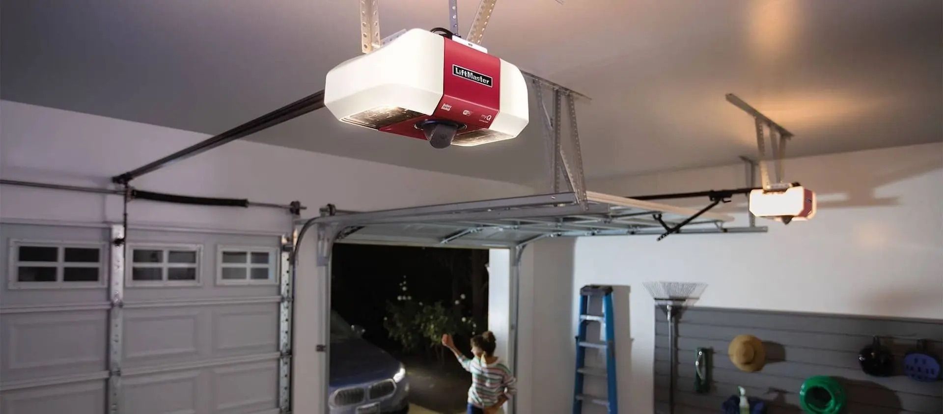 Garage interior with a red ceiling-mounted garage door opener above an open garage door