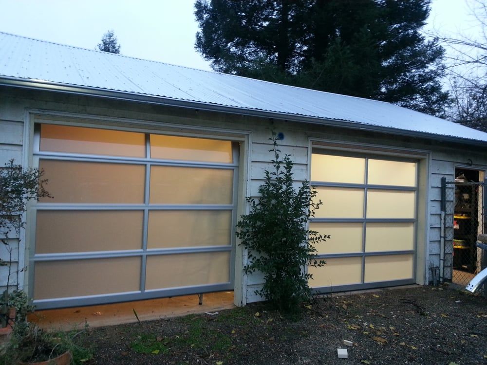 a garage with a white roof and a few trees in the background