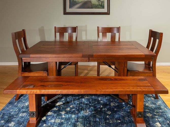 A dining room table with a bench and chairs