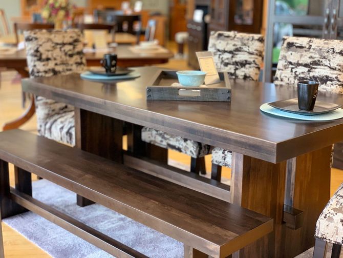 A wooden dining table with a bench and chairs in a room.
