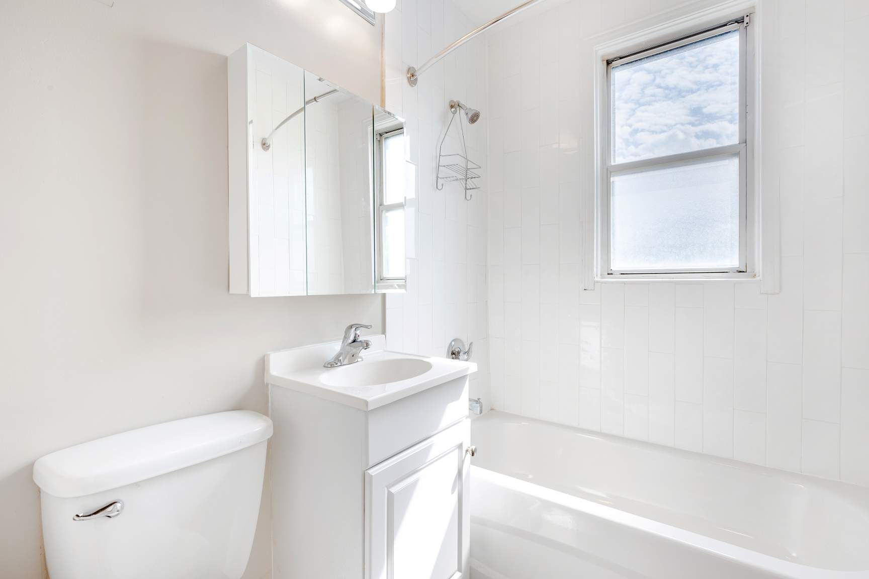 A bathroom with a toilet , sink , and bathtub.