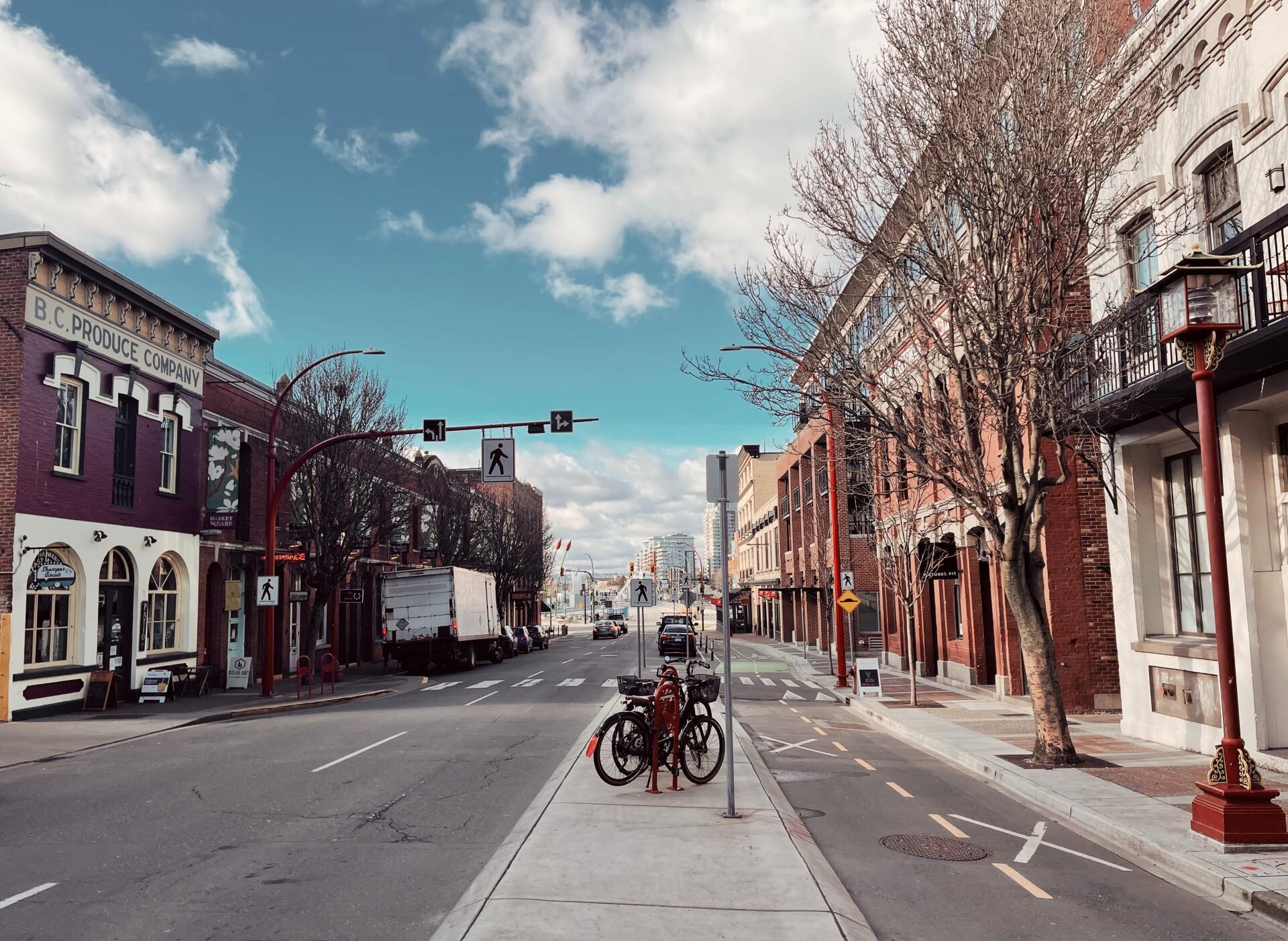 A bicycle is parked on the sidewalk in the middle of a city street.