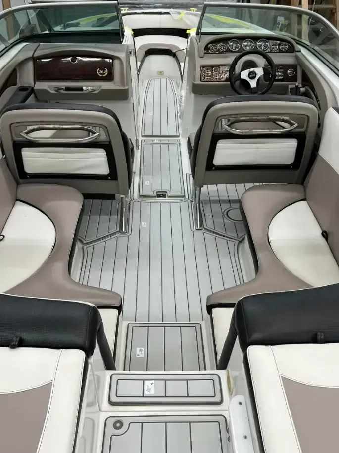 Interior of a boat with gray, white, and black seating and flooring.