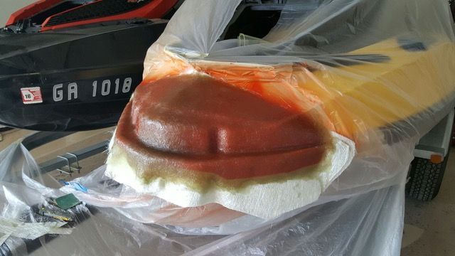 Brown, reddish object covered in plastic, on top of a yellow object.