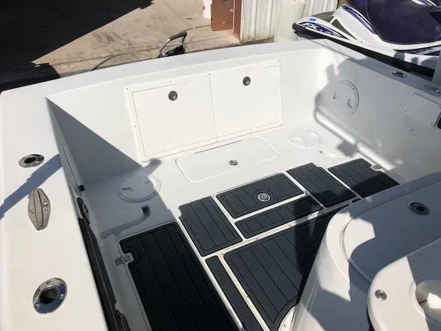 Boat interior with white compartments and black patterned flooring.