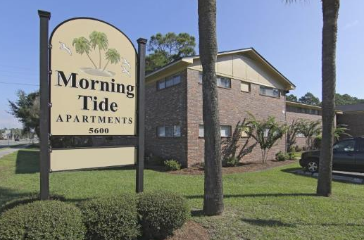 A sign for morning tide apartments is in front of a building