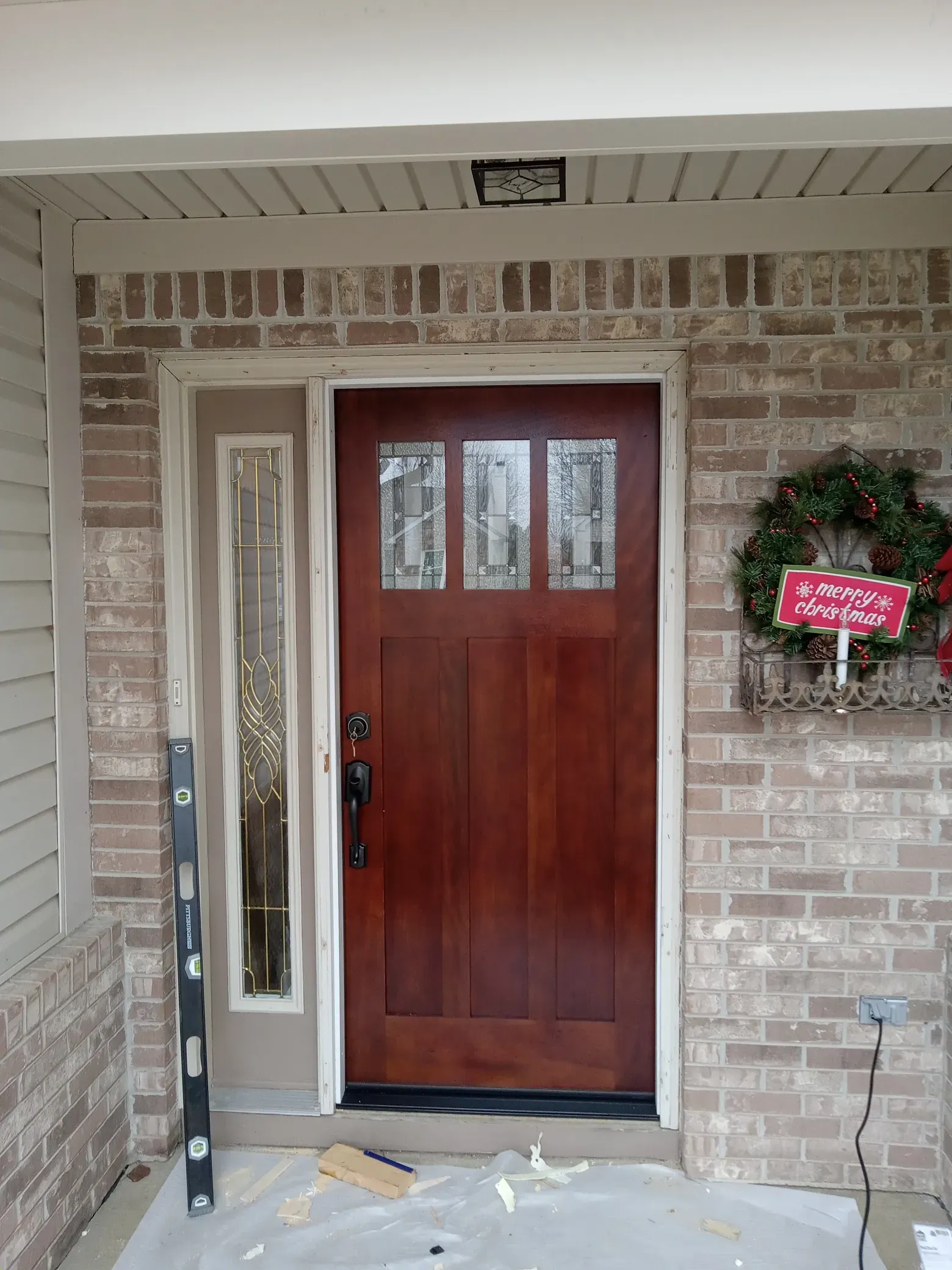 Front door installation with wood finish and upgraded entryway for handyman repair service