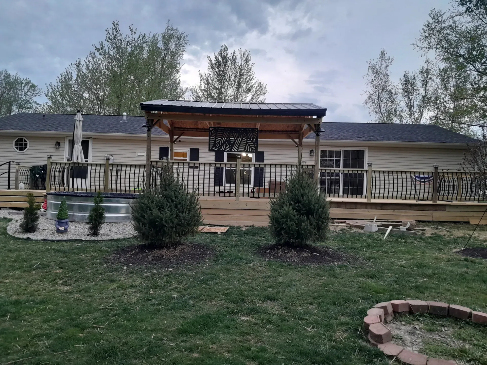 Spacious backyard deck with pergola roof installed by professional handyman deck builders