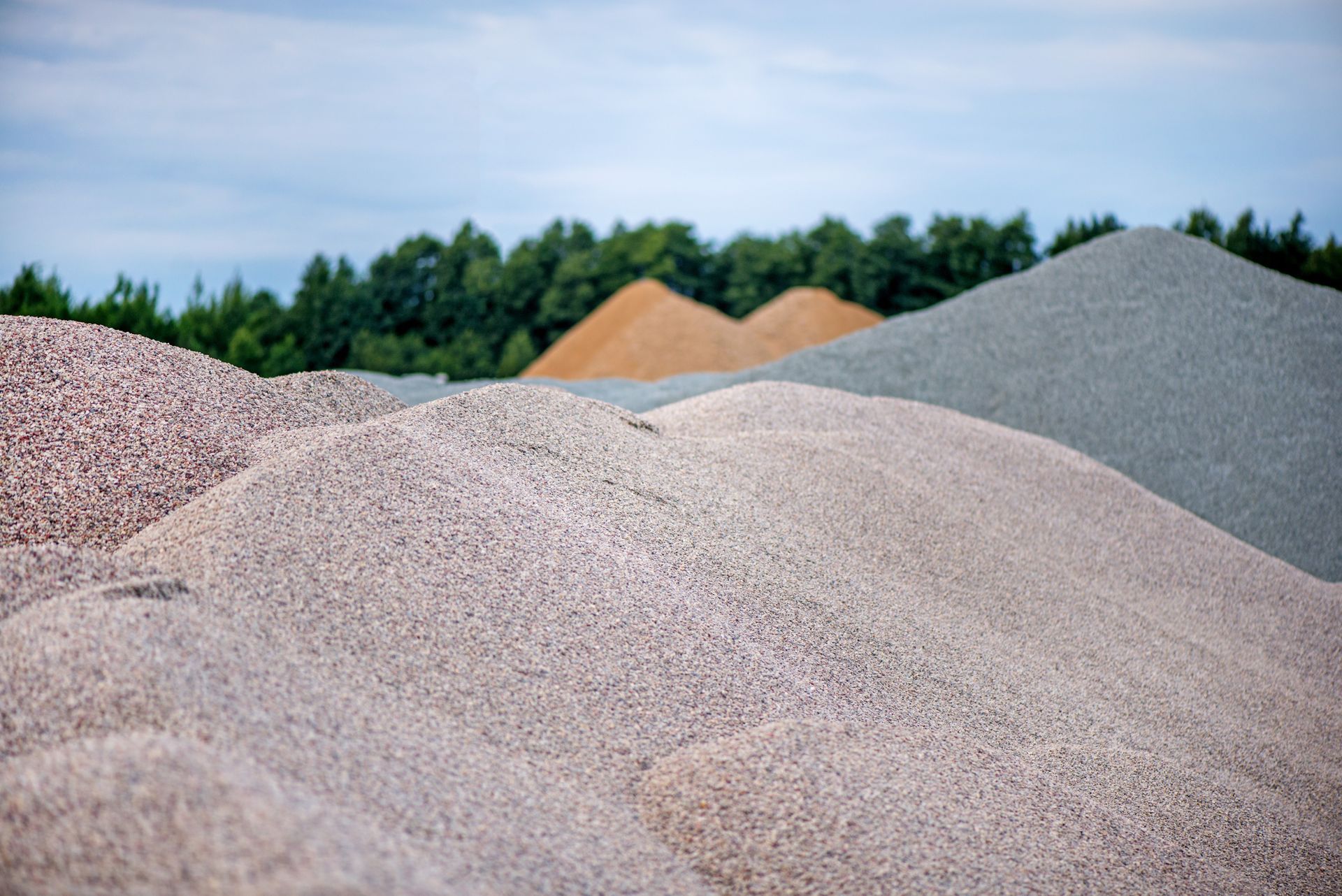 Une illustration colorée, dessinée à la main, représentant un paysage de montagne fantaisiste sous un soleil jaune éclatant.